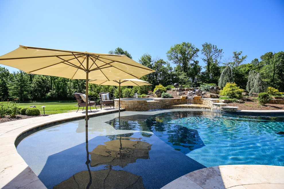 На фото: бассейн в форме фасоли на заднем дворе в классическом стиле с фонтаном