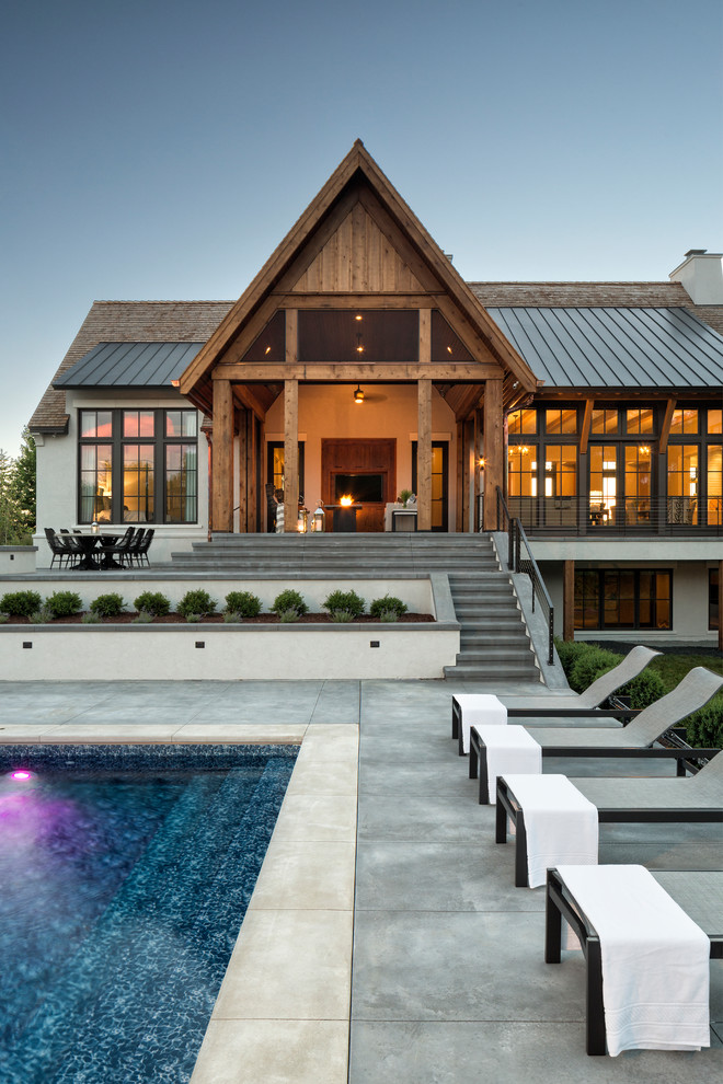 Idée de décoration pour une piscine arrière champêtre rectangle avec une dalle de béton.