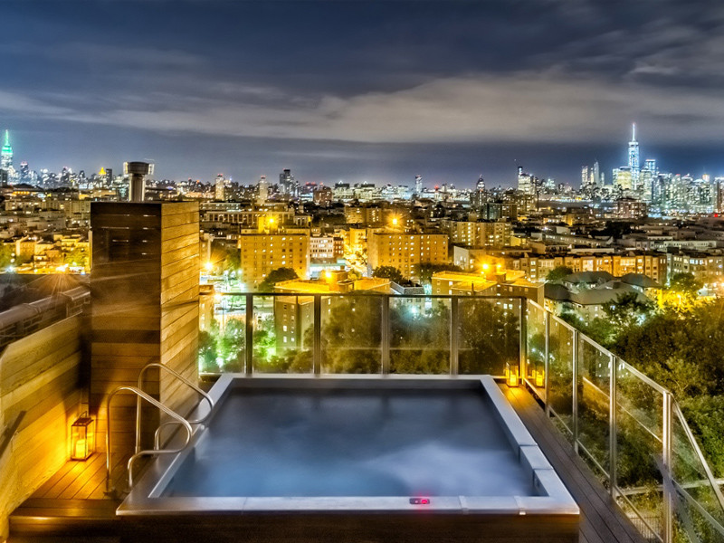 Minimalist rooftop rectangular aboveground hot tub photo in New York with decking