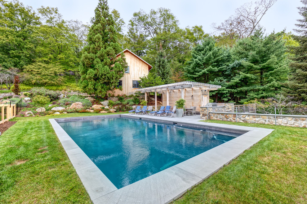 Immagine di una piscina country rettangolare con pavimentazioni in cemento