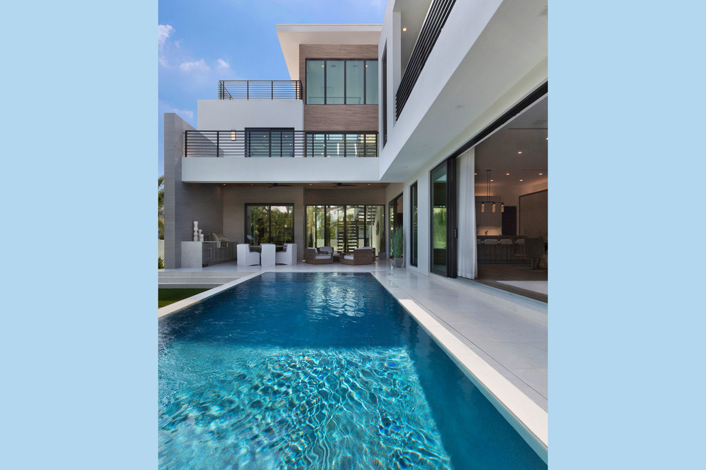 Immagine di una piscina a sfioro infinito minimalista rettangolare di medie dimensioni e dietro casa con cemento stampato