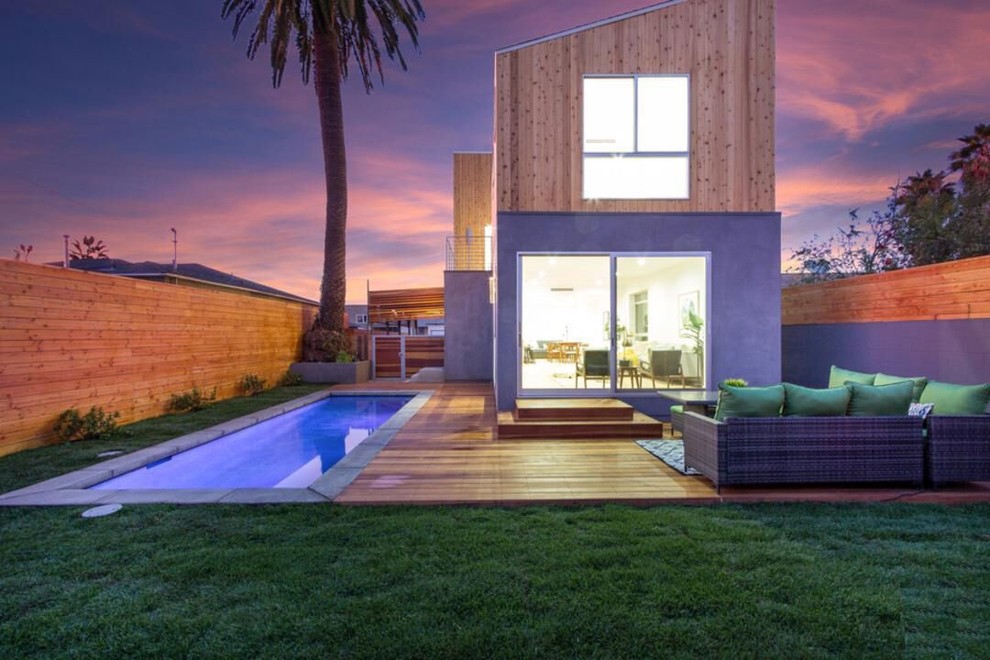 Ejemplo de piscina alargada moderna de tamaño medio rectangular en patio trasero con entablado
