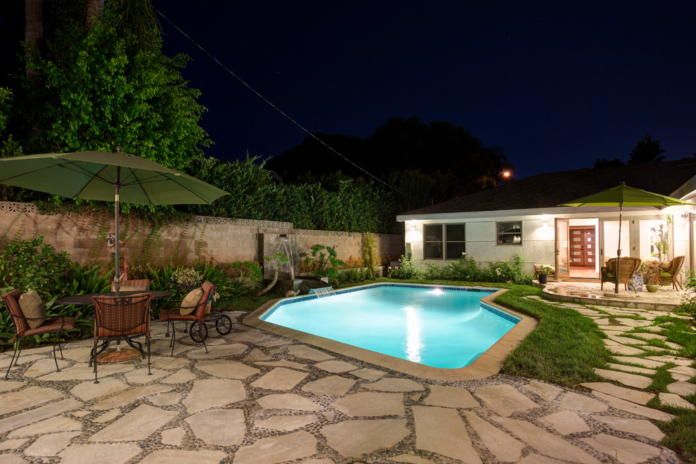 Ejemplo de piscina con fuente natural minimalista de tamaño medio a medida en patio trasero con adoquines de piedra natural