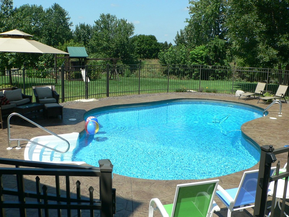 Foto på en mellanstor vintage pool på baksidan av huset, med stämplad betong