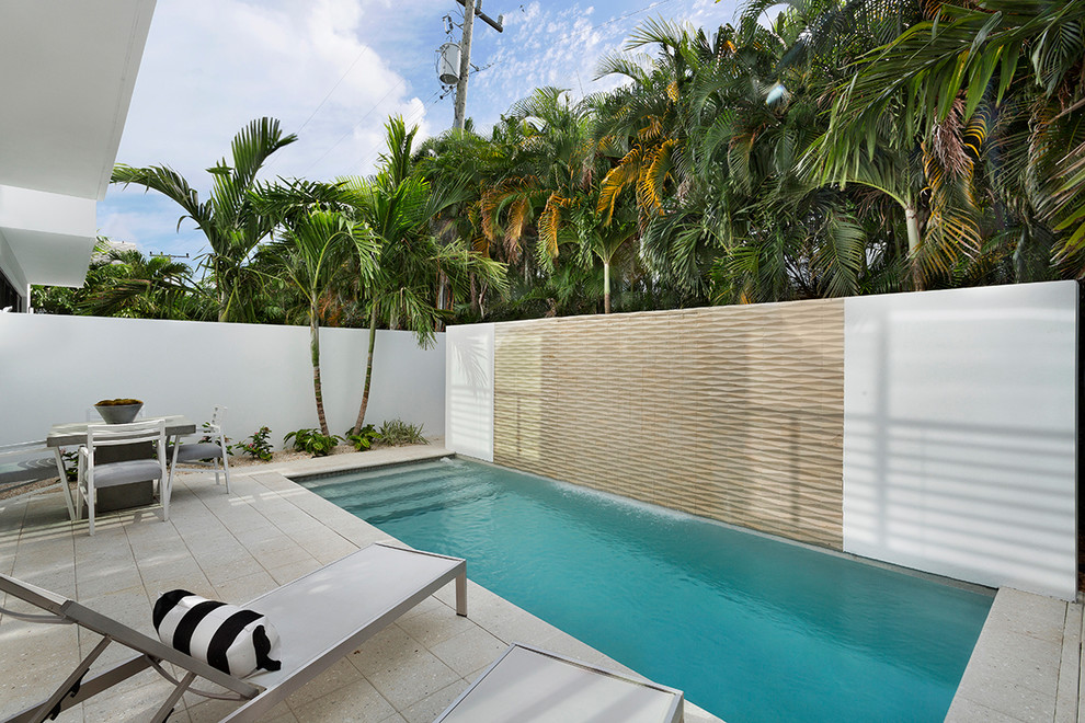 Immagine di una piscina naturale minimalista rettangolare di medie dimensioni e dietro casa con cemento stampato