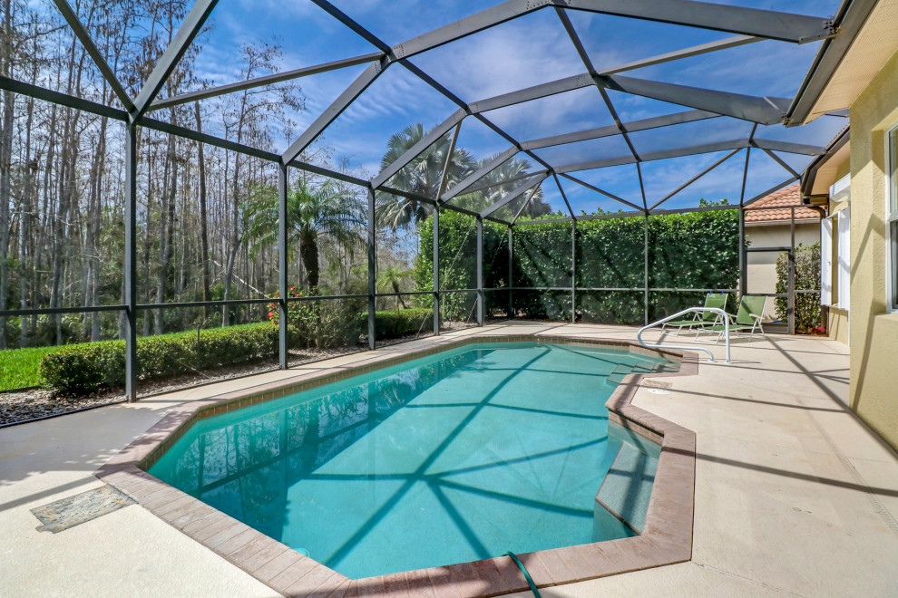 Ispirazione per una piscina naturale classica personalizzata di medie dimensioni e dietro casa con lastre di cemento