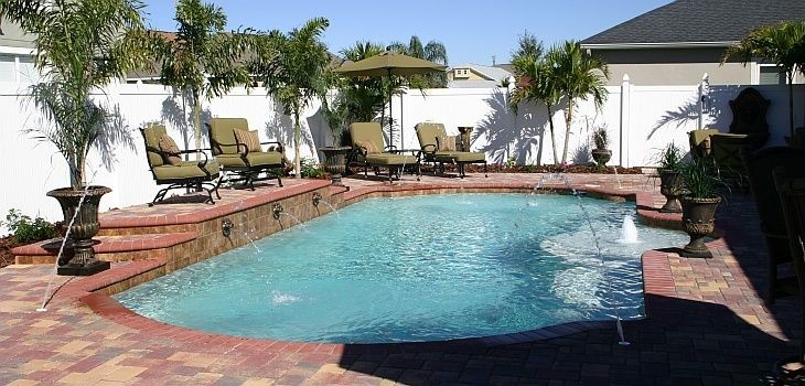 Foto de piscina con fuente moderna de tamaño medio a medida en patio trasero con adoquines de ladrillo