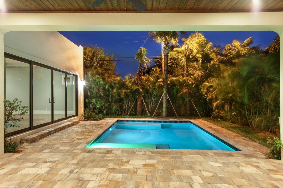 Inspiration för en mellanstor retro anpassad pool på baksidan av huset, med en fontän och naturstensplattor