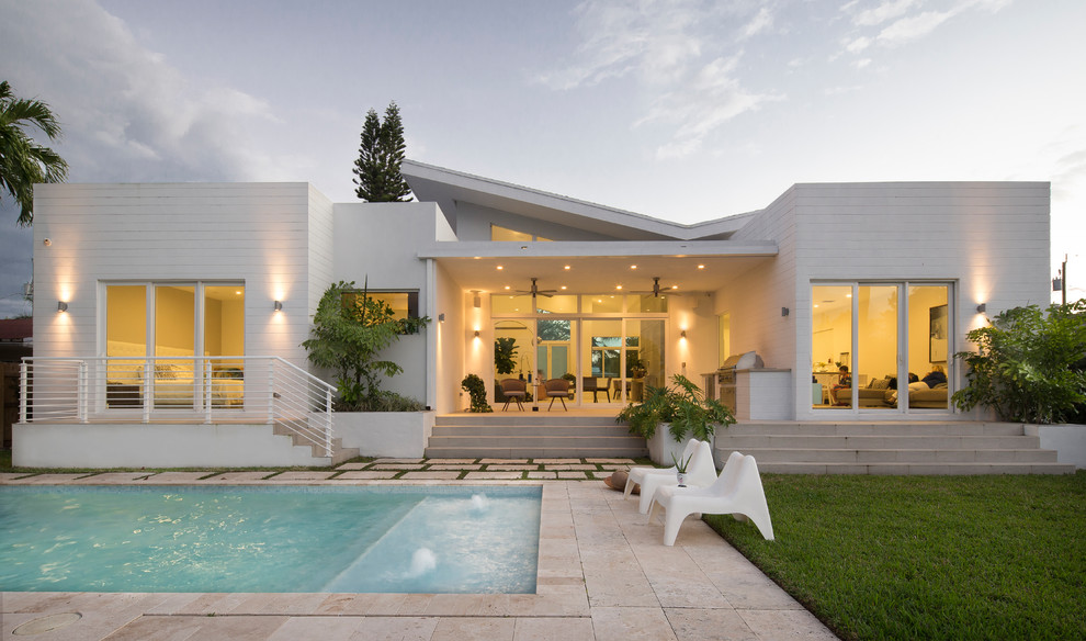 Moderner Pool hinter dem Haus in rechteckiger Form mit Wasserspiel in Miami