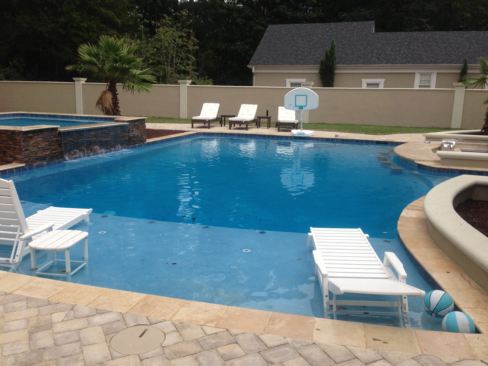 Idee per una grande piscina monocorsia tradizionale rettangolare dietro casa con una vasca idromassaggio e pavimentazioni in cemento