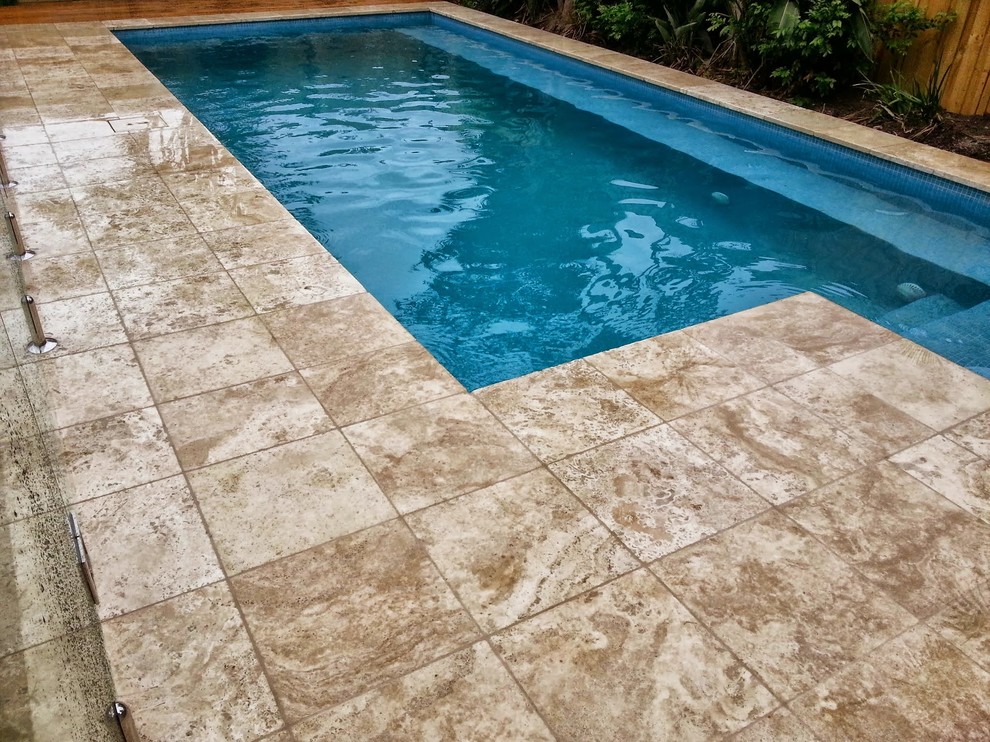 Imagen de piscina alargada marinera pequeña rectangular en patio trasero con adoquines de piedra natural