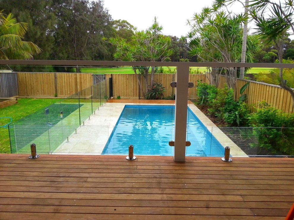 Example of a small beach style backyard stone and rectangular lap pool design in Sydney