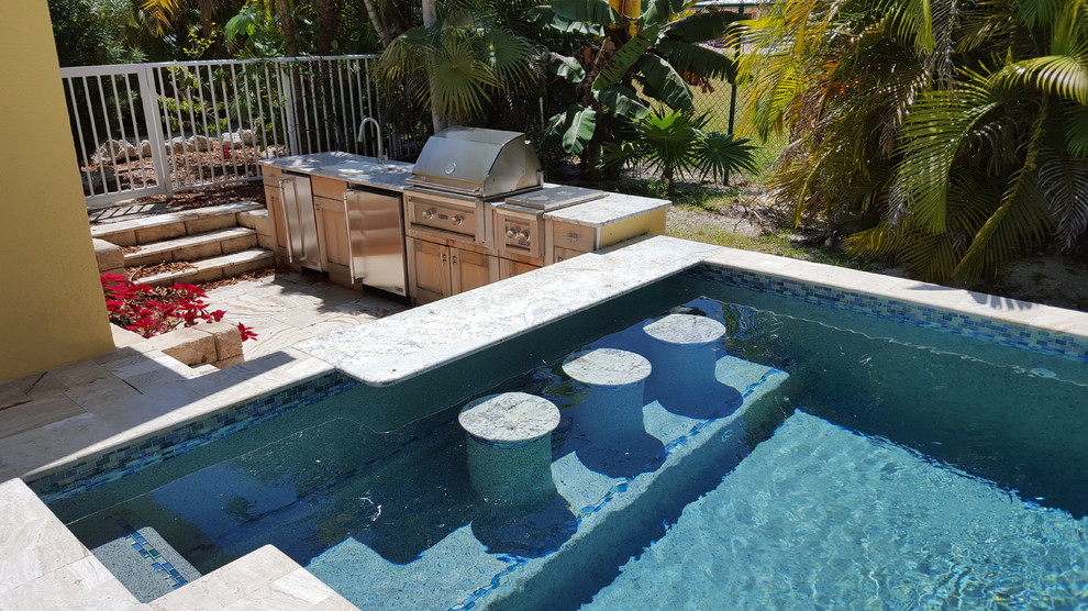 Imagen de piscinas y jacuzzis exóticos de tamaño medio rectangulares en patio trasero con adoquines de piedra natural