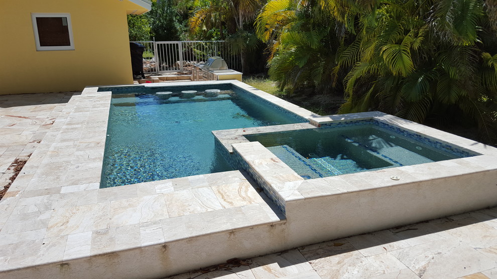 На фото: естественный, прямоугольный бассейн среднего размера на заднем дворе в морском стиле с джакузи и покрытием из каменной брусчатки с