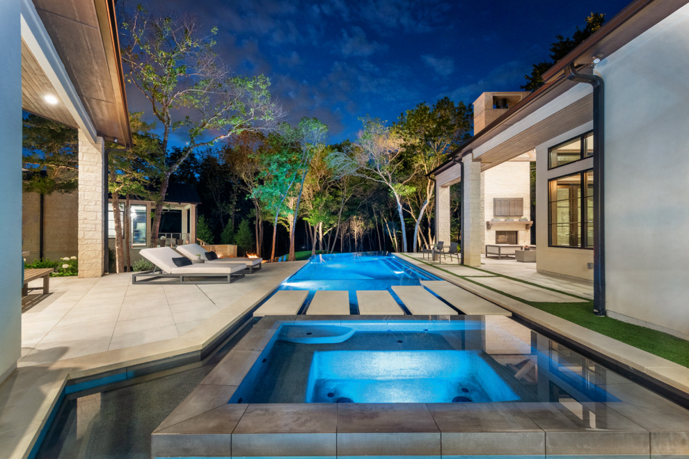 Large trendy backyard concrete and custom-shaped infinity pool photo in Dallas