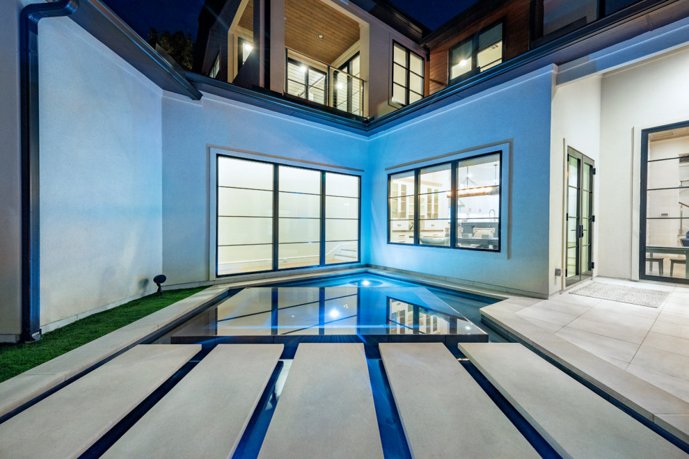 Großer Moderner Infinity-Pool hinter dem Haus in individueller Form mit Betonplatten in Dallas