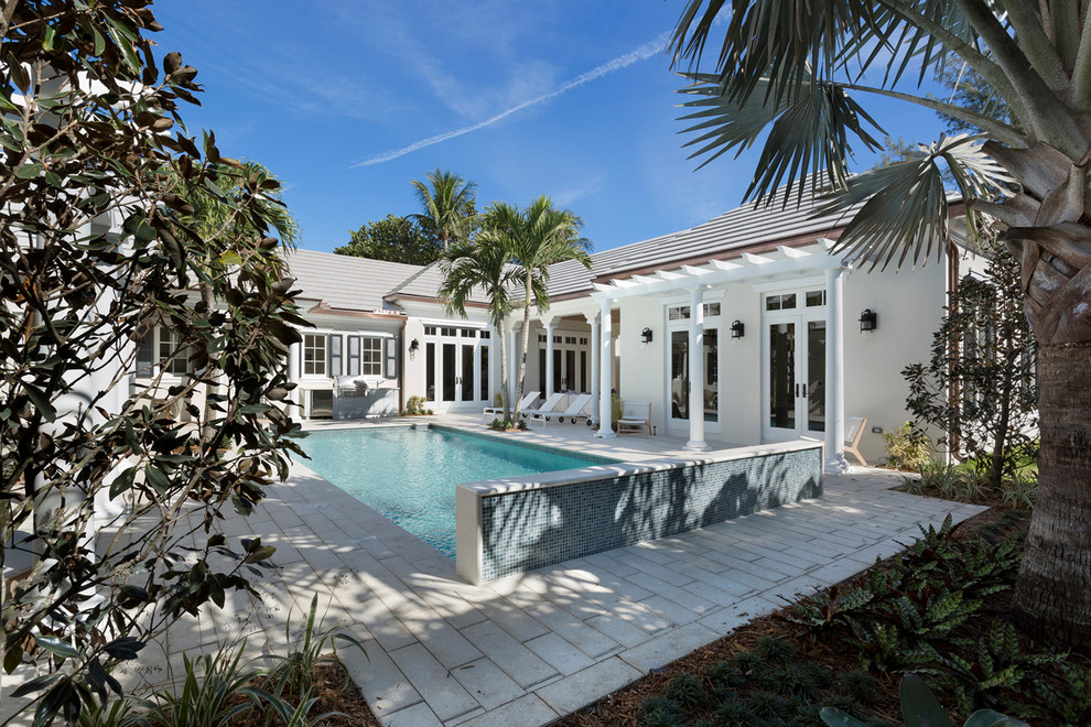 Design ideas for a large world-inspired back rectangular lengths swimming pool in Miami with concrete paving.