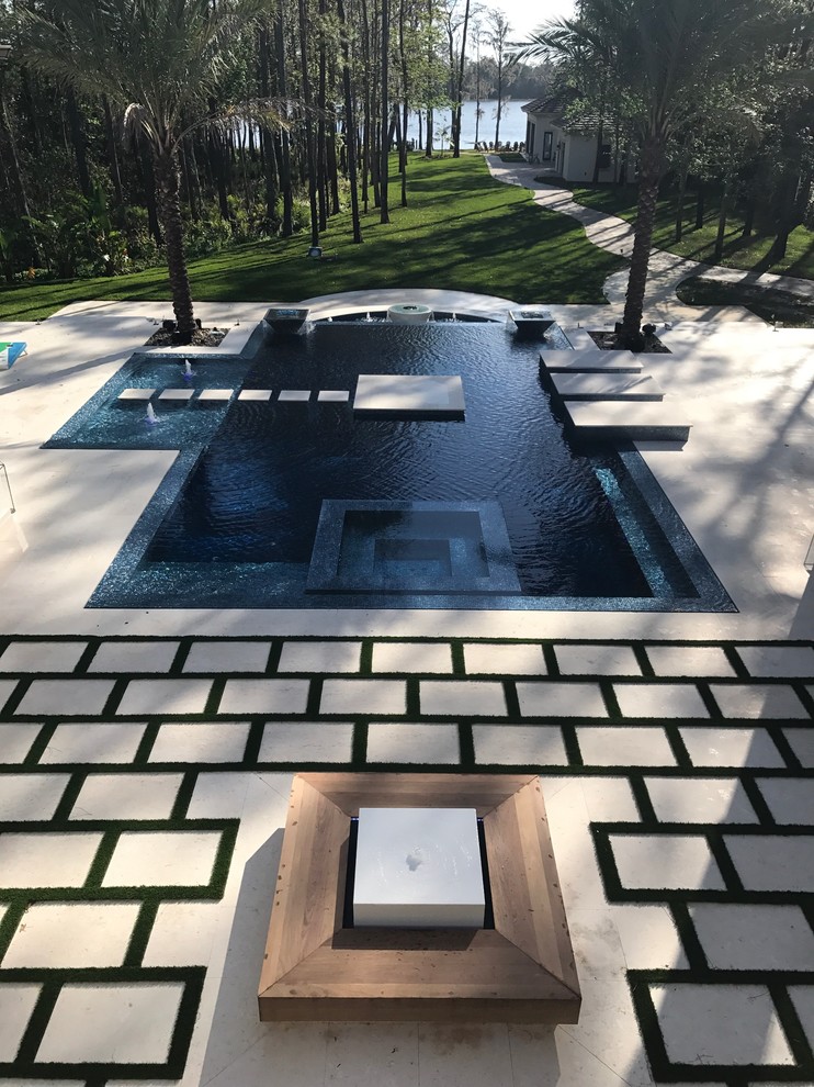 Foto de piscina con fuente infinita moderna extra grande a medida en patio trasero