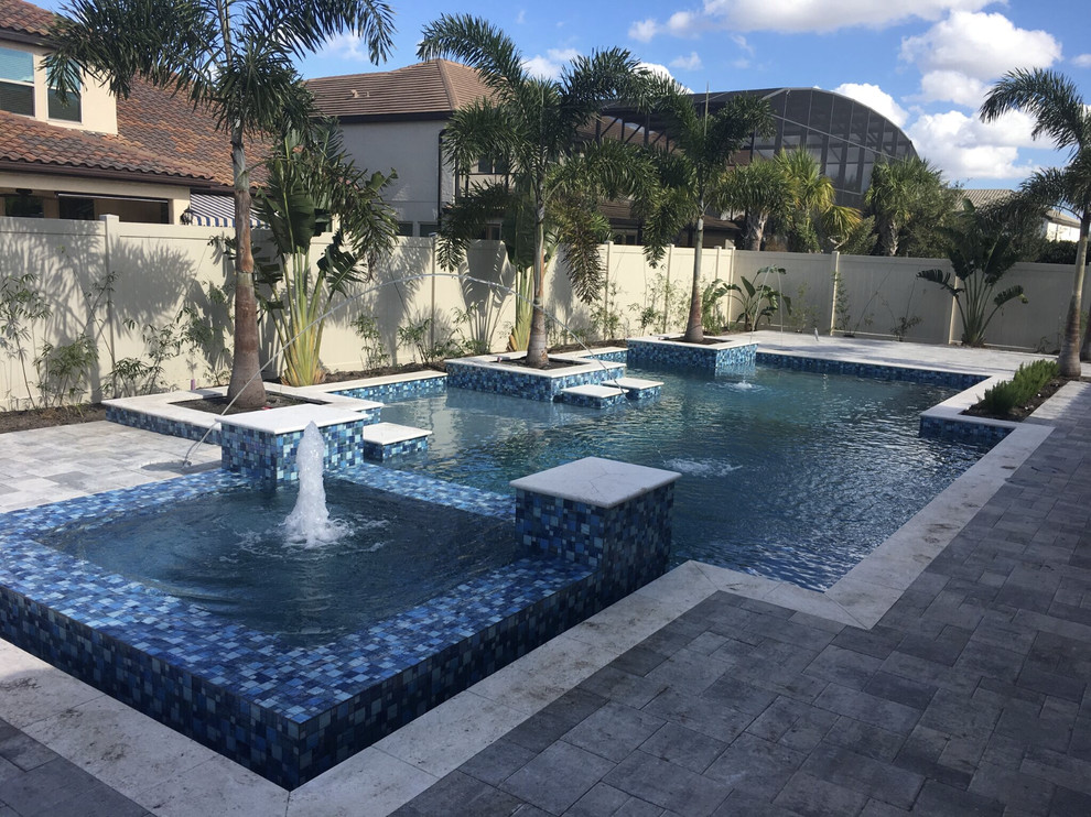 Modelo de piscina natural minimalista extra grande a medida en patio trasero con adoquines de piedra natural
