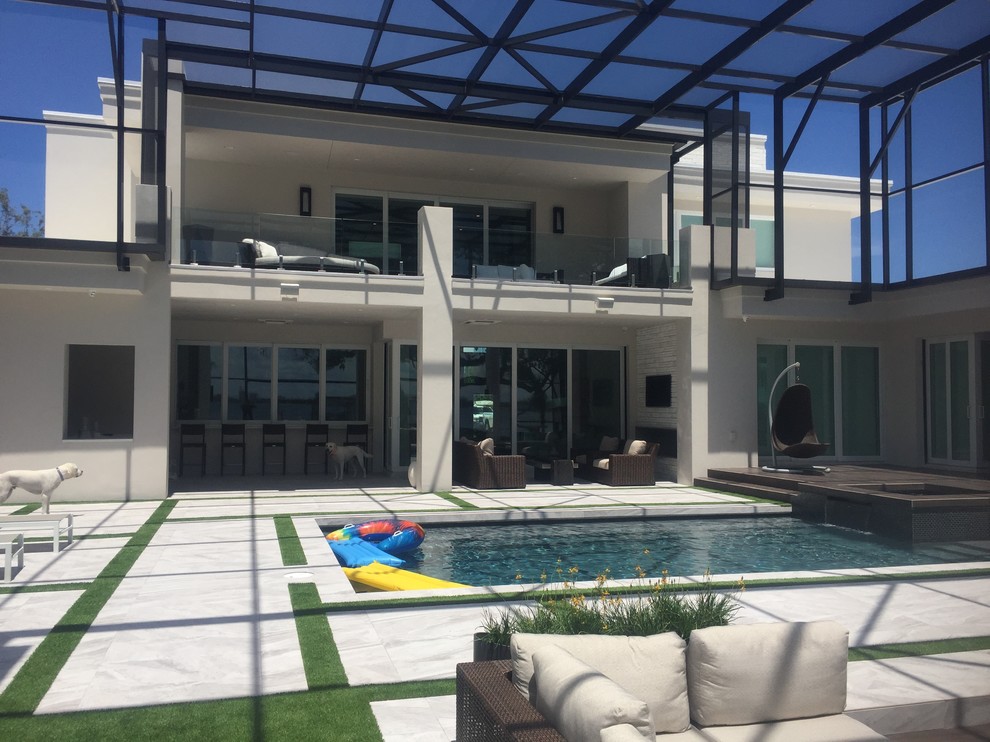 Huge minimalist backyard custom-shaped natural pool photo in Orlando with decking