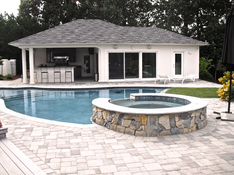 Ispirazione per una grande piscina minimal dietro casa con una vasca idromassaggio e pavimentazioni in cemento