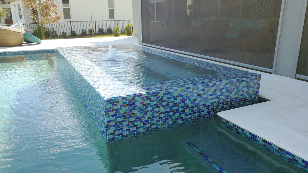 Foto de casa de la piscina y piscina infinita moderna extra grande a medida en patio trasero