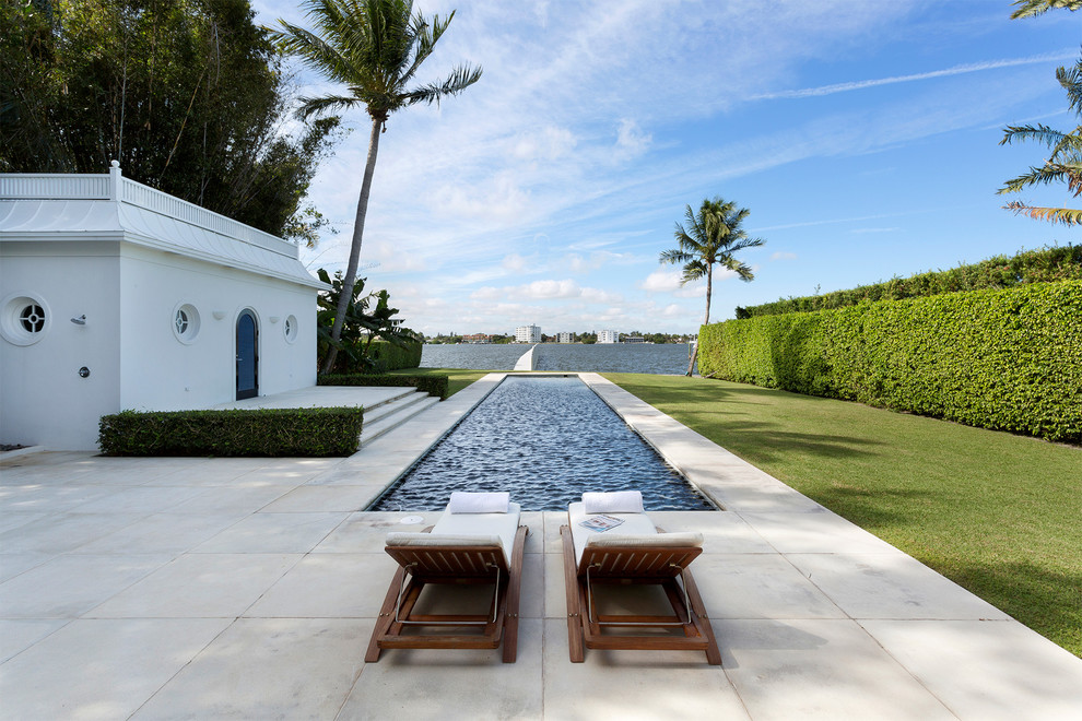 Immagine di una piscina monocorsia design rettangolare dietro casa e di medie dimensioni con pavimentazioni in cemento