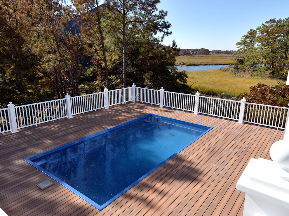 Example of a small beach style side yard rectangular aboveground pool design in Other with decking