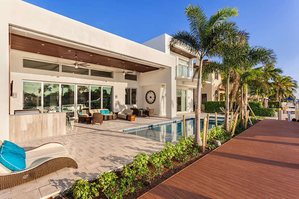 Diseño de piscinas y jacuzzis alargados minimalistas de tamaño medio rectangulares en patio trasero con adoquines de hormigón