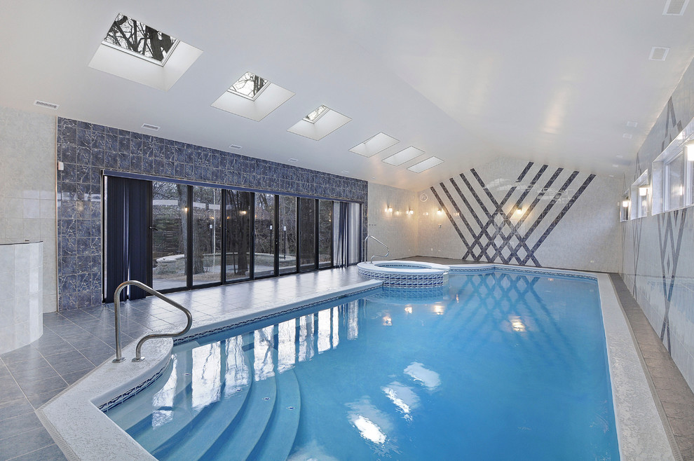 Esempio di un'ampia piscina coperta monocorsia design personalizzata con una vasca idromassaggio e piastrelle