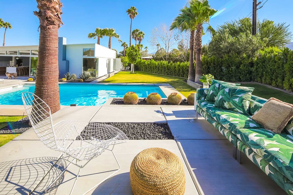 Foto de piscina vintage grande rectangular en patio trasero con losas de hormigón