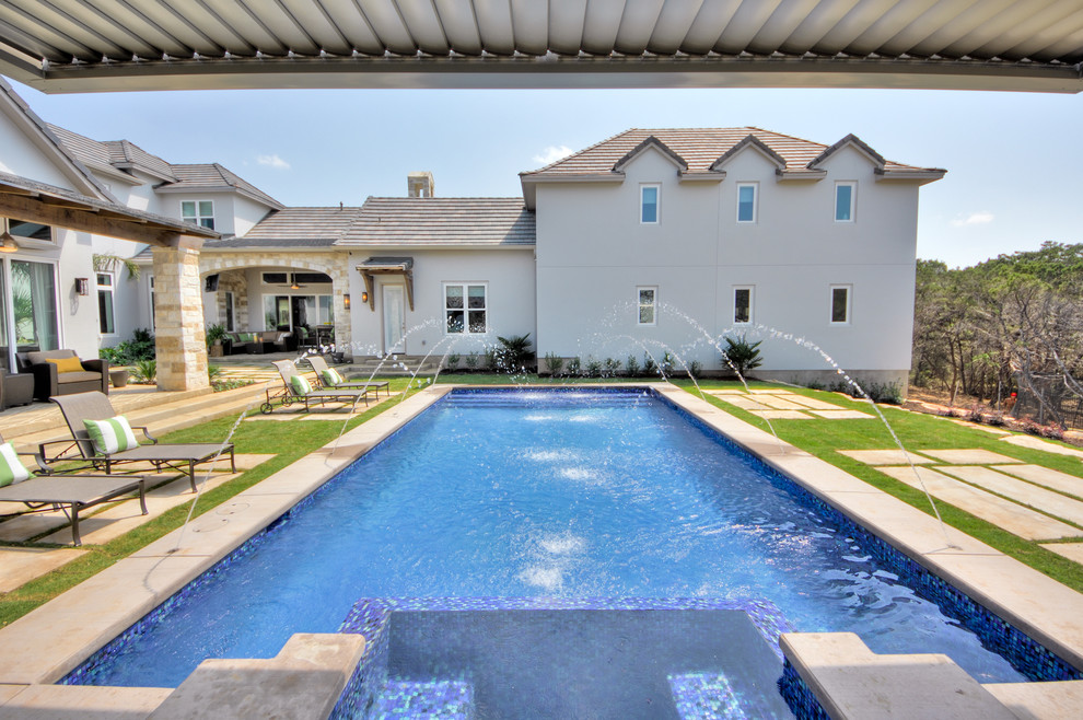 Ejemplo de piscinas y jacuzzis contemporáneos grandes rectangulares en patio trasero con losas de hormigón
