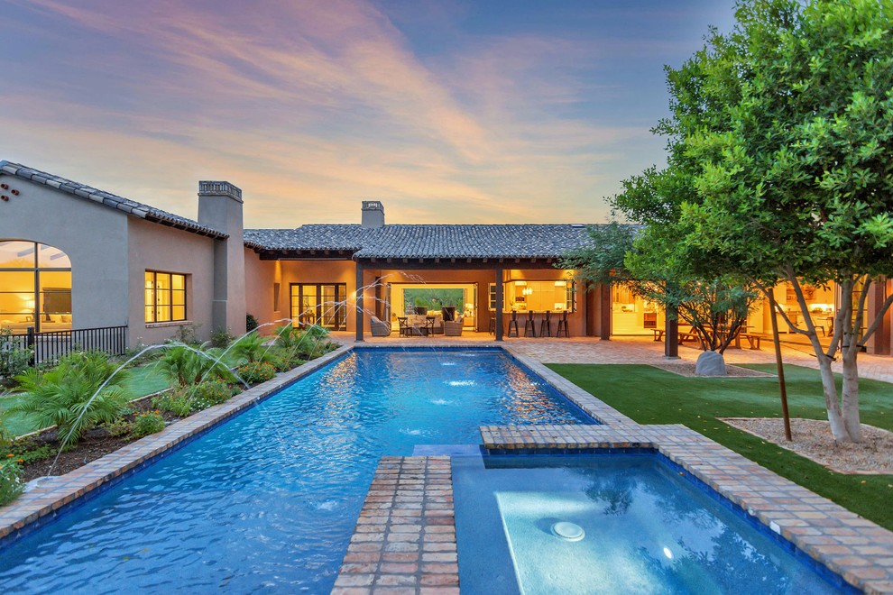 Photo of a mediterranean back rectangular swimming pool in Phoenix with a water feature.