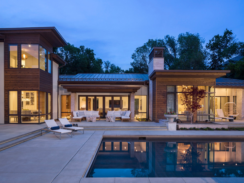 Photo of a large contemporary back rectangular lengths swimming pool in Salt Lake City with concrete slabs.