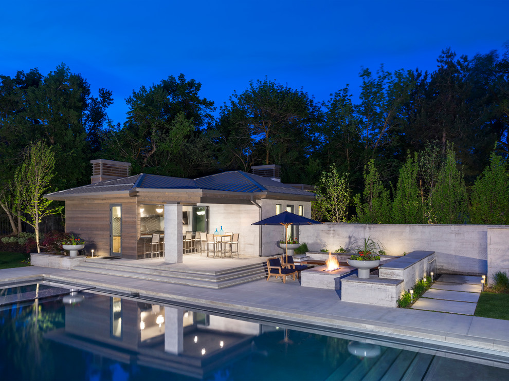 Imagen de casa de la piscina y piscina alargada contemporánea grande rectangular en patio trasero con losas de hormigón