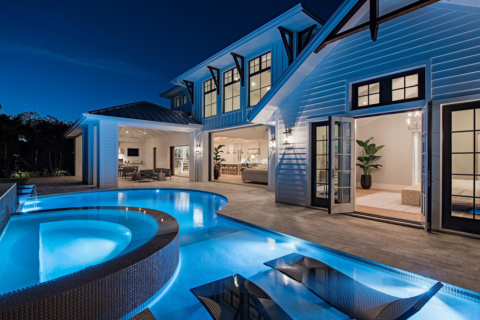 Esempio di una piscina stile marino personalizzata dietro casa con una vasca idromassaggio