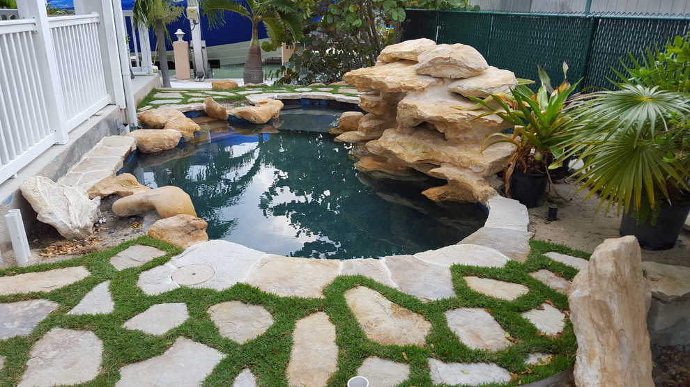 Idee per una piccola piscina naturale tropicale personalizzata dietro casa con fontane e pavimentazioni in pietra naturale