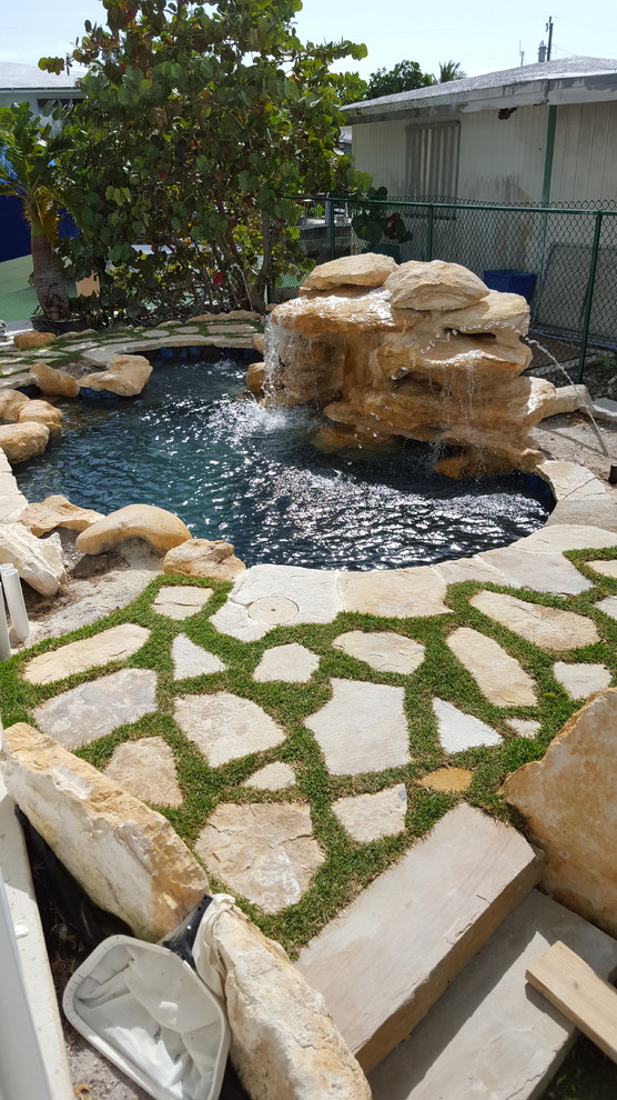 Pool fountain - small tropical backyard stone and custom-shaped natural pool fountain idea in Miami