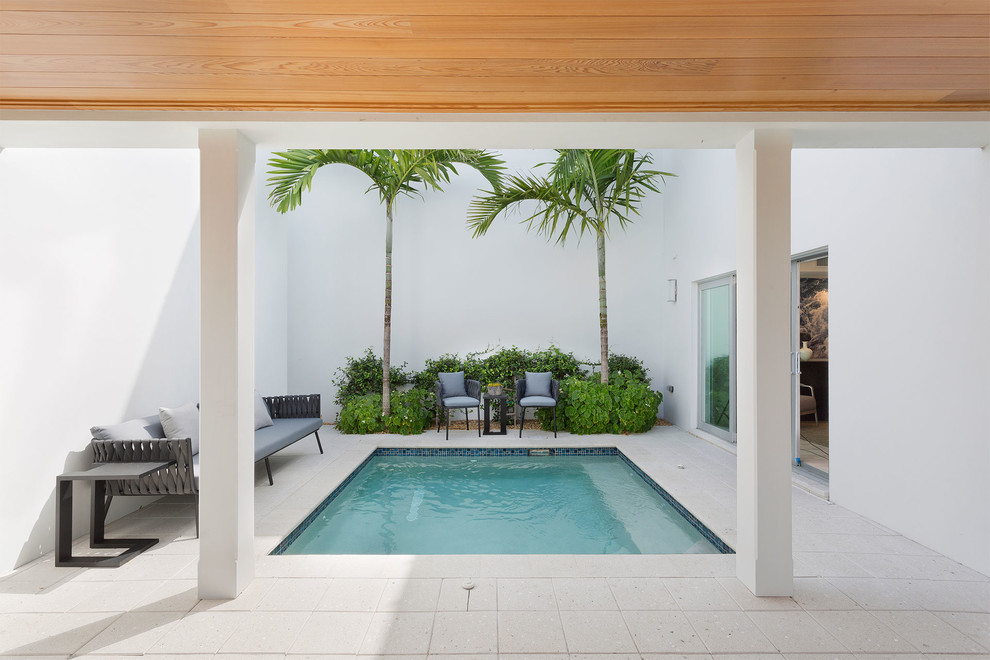 Modelo de piscina natural contemporánea de tamaño medio rectangular en patio lateral con suelo de hormigón estampado