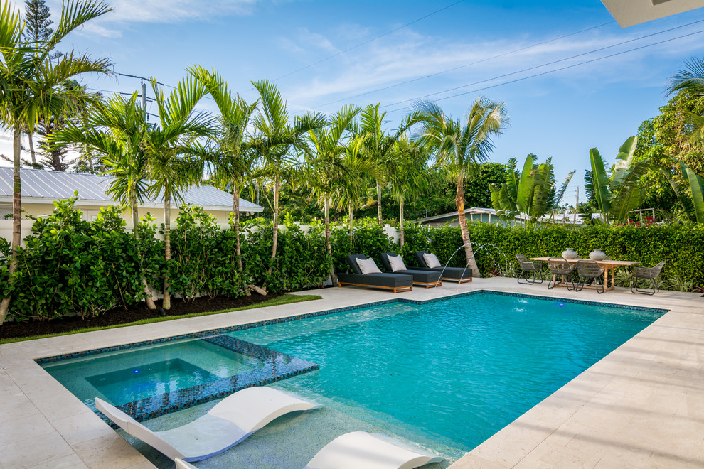 Gefliestes Sportbecken hinter dem Haus in rechteckiger Form mit Wasserspiel in Miami