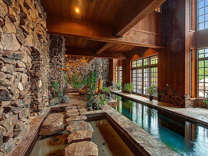 Photo of a medium sized rustic indoor rectangular swimming pool in Seattle with a water feature and natural stone paving.