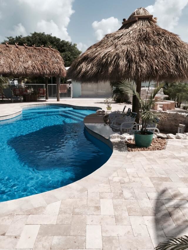 Bild på en stor tropisk anpassad baddamm på baksidan av huset, med naturstensplattor