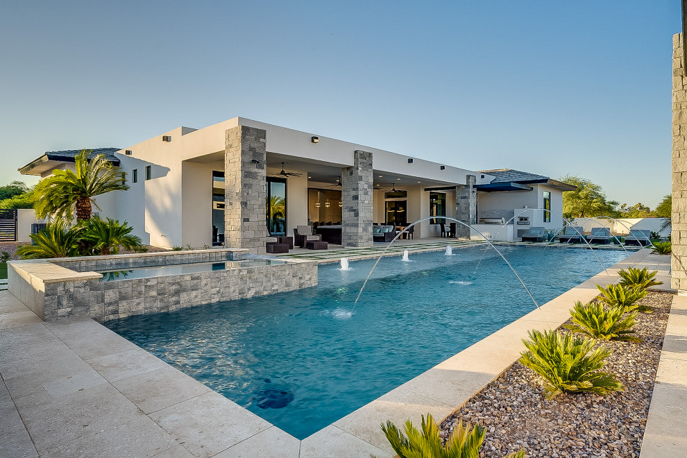Imagen de piscina con fuente alargada de estilo americano rectangular en patio trasero