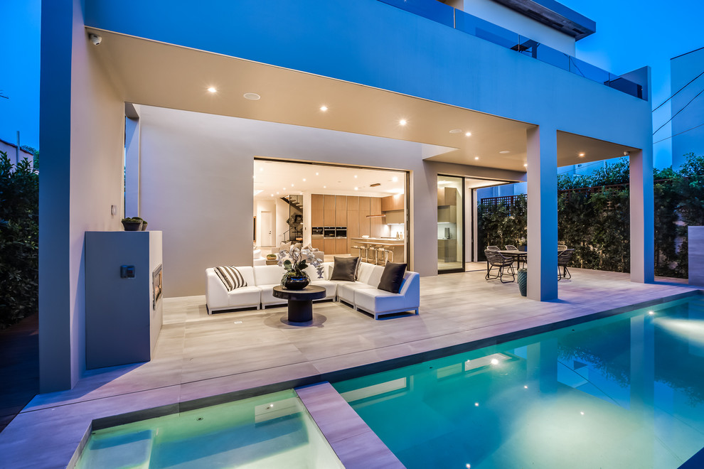 Idee per una grande piscina monocorsia moderna rettangolare dietro casa con fontane e piastrelle
