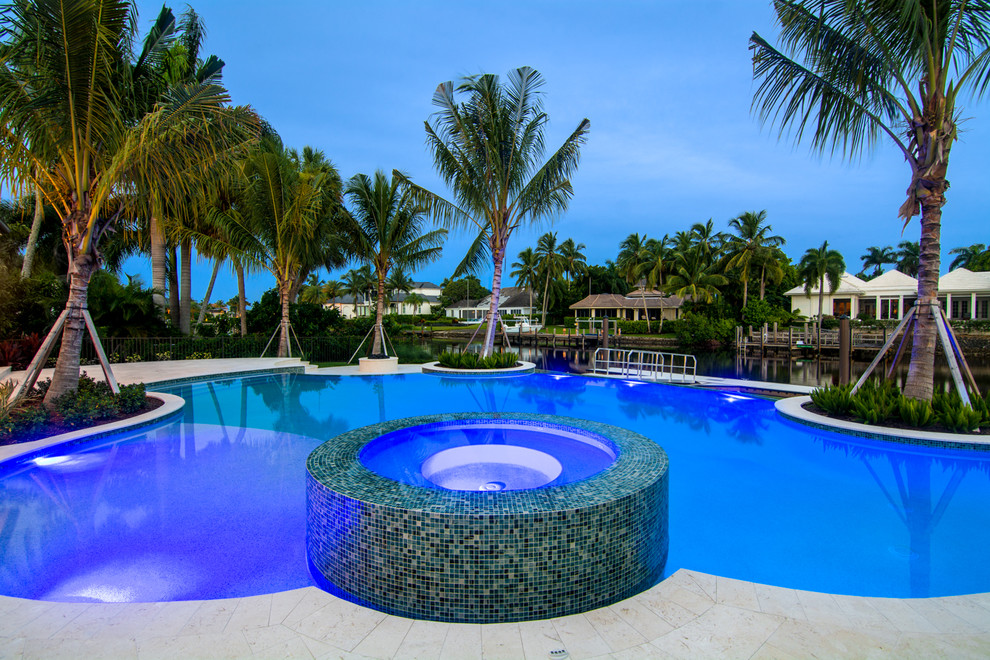 Large transitional backyard custom-shaped infinity pool photo in Miami