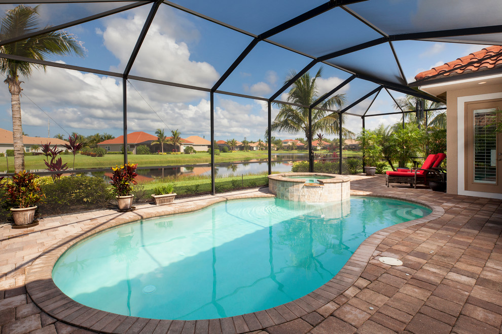 Tuscan indoor brick and kidney-shaped lap pool photo in Miami