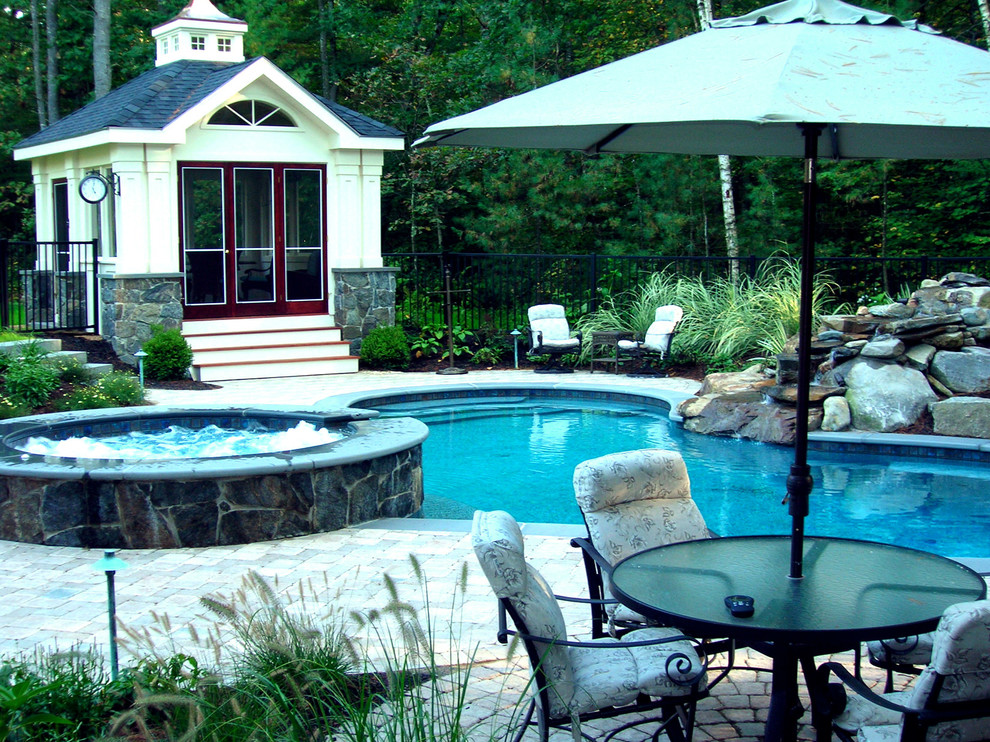 Diseño de piscina con fuente clásica de tamaño medio a medida en patio trasero con losas de hormigón