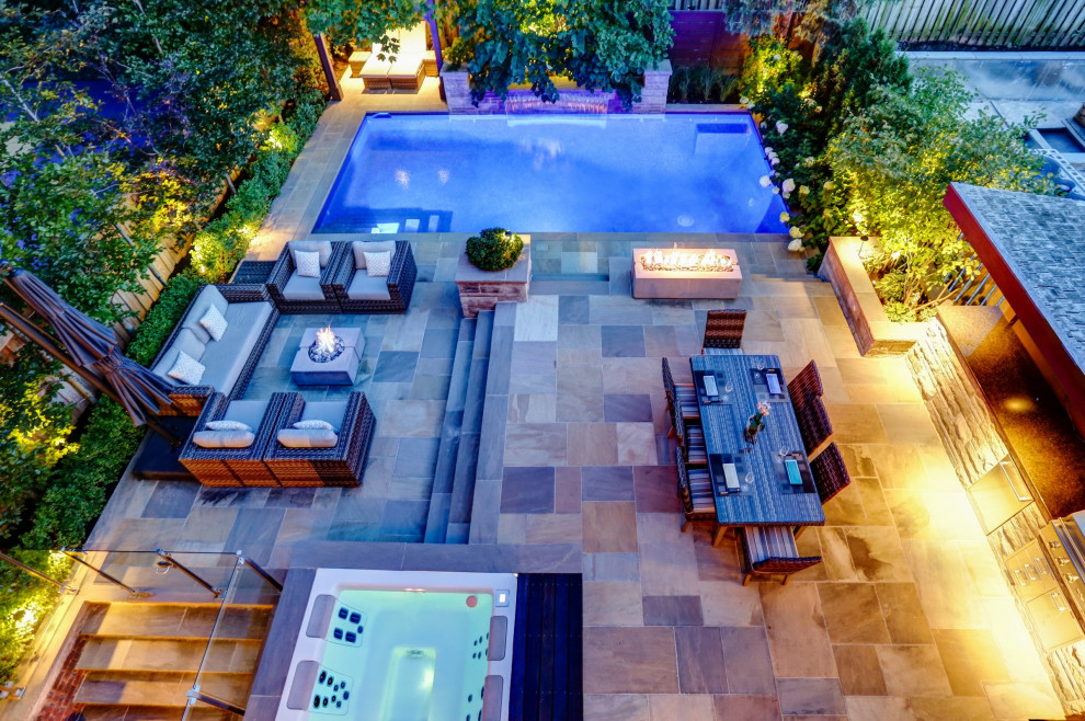 Imagen de piscina clásica renovada de tamaño medio rectangular en patio trasero con privacidad y adoquines de piedra natural