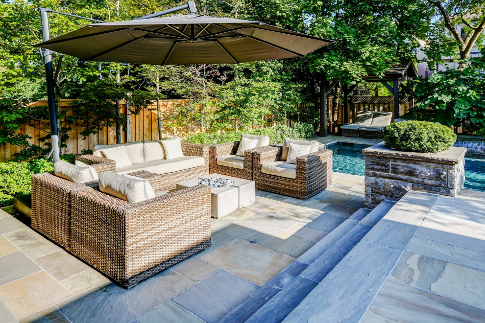 Ejemplo de piscina clásica renovada de tamaño medio rectangular en patio trasero con privacidad y adoquines de piedra natural