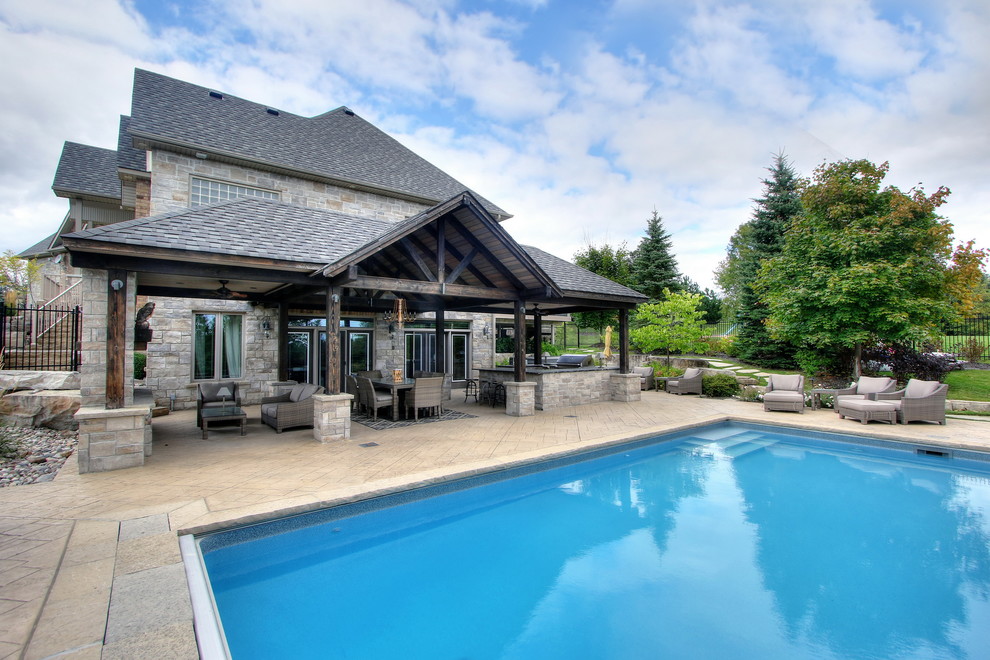Foto di una piscina classica rettangolare di medie dimensioni e dietro casa con una dépendance a bordo piscina e cemento stampato